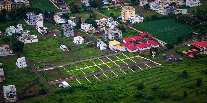 Aerial view of surveyed residential plots marked out in a grid beside an existing settlement